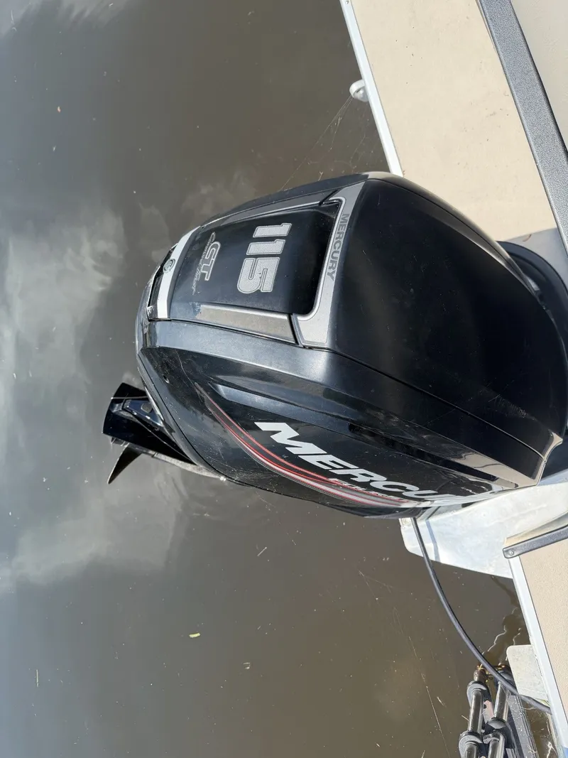 Slide: The Image of A Mercury outboard motor on a boat in calm water. - 12