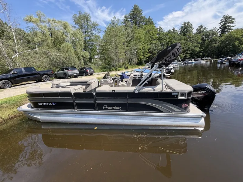 Slide: The Image of A 2014 Premier 240 SunSation pontoon boat on the water, surrounded by trees. - 2