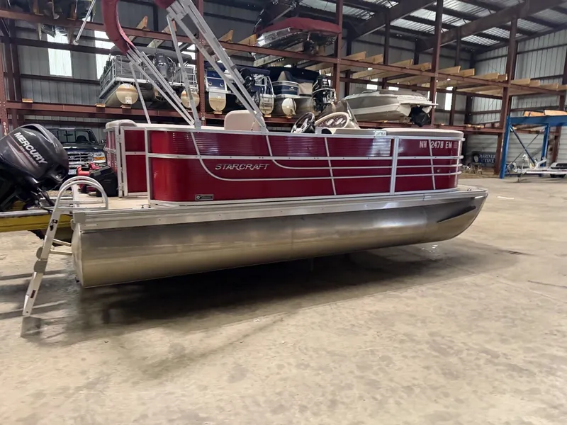 Slide: The Image of A red 2014 Starcraft pontoon boat is in a warehouse. - 10