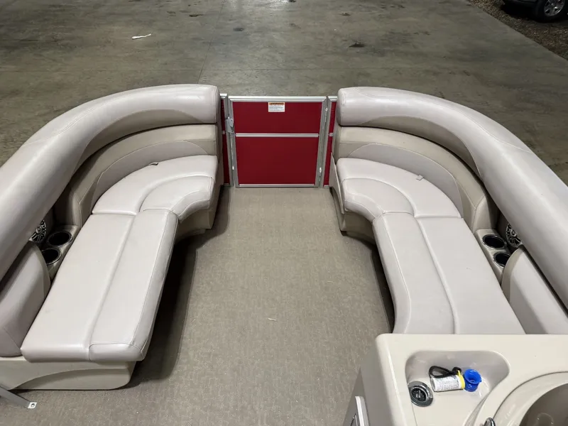 Slide: The Image of Interior of a Starcraft 18Ft pontoon boat with beige seating and a red railing. - 12