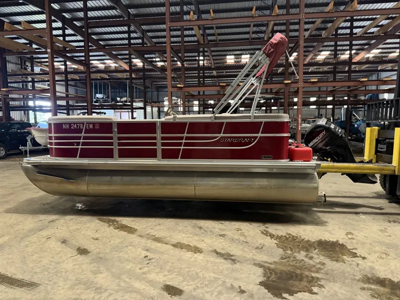 Slide: The Image of A red 2014 Starcraft pontoon boat is parked in a warehouse. - 8