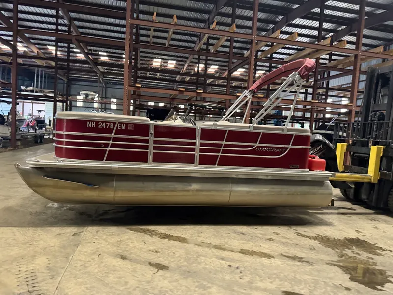 Slide: The Image of A red 2014 Starcraft pontoon boat is in a warehouse on a concrete floor. - 4
