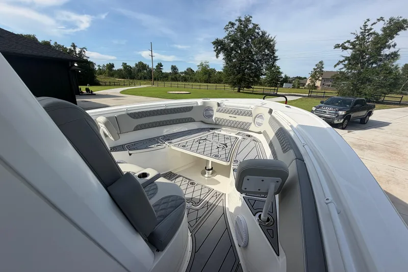 Slide: The Image of 2024 Sea Pro 322 Offshore boat interior with seating and deck, parked outdoors. - 10