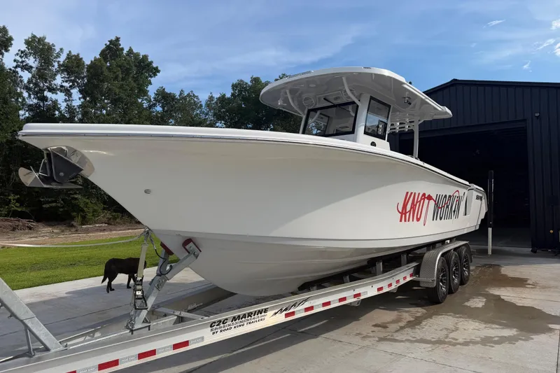 Slide: The Image of 2024 Sea Pro 322 Offshore boat on trailer, parked outdoors near a building. - 4
