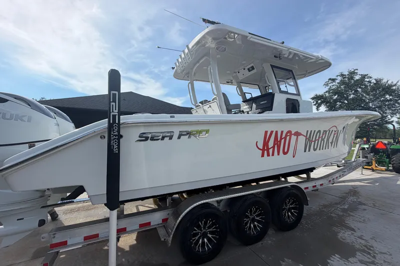 Slide: The Image of 2024 Sea Pro 322 Offshore boat on trailer, featuring dual Suzuki engines. - 8