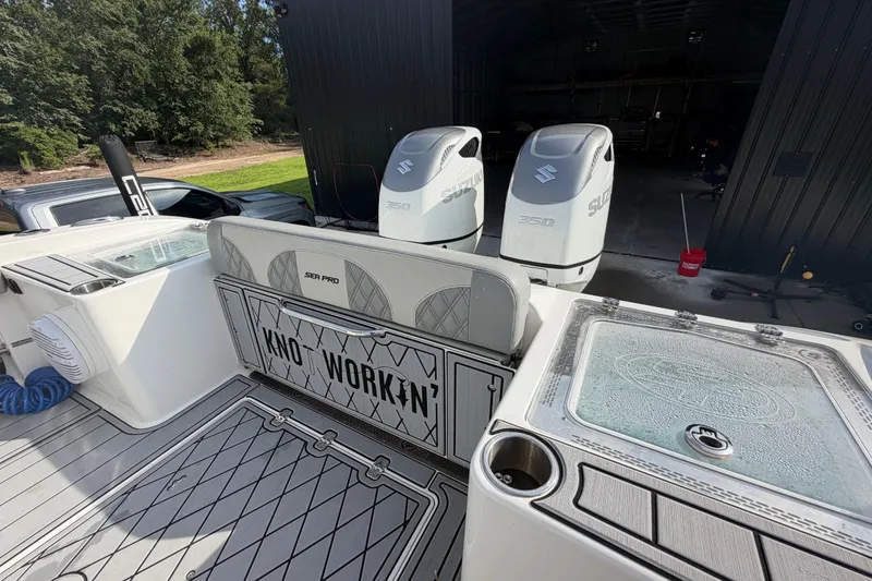 Slide: The Image of 2024 Sea Pro 322 Offshore boat with dual Suzuki engines in a garage setting. - 14