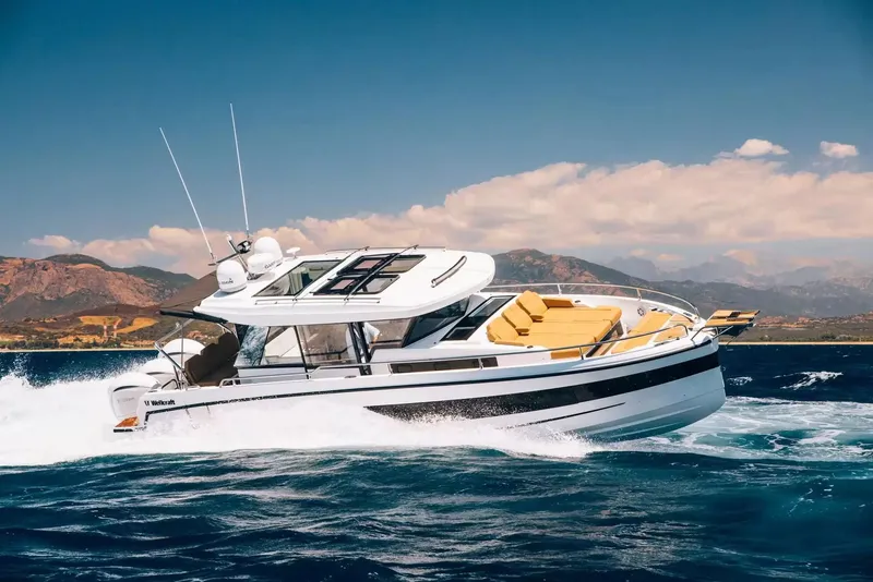 Slide: The Image of A 2027 Wellcraft 38 Explorer speeds across the water with a mountainous coastline in the background. - 3