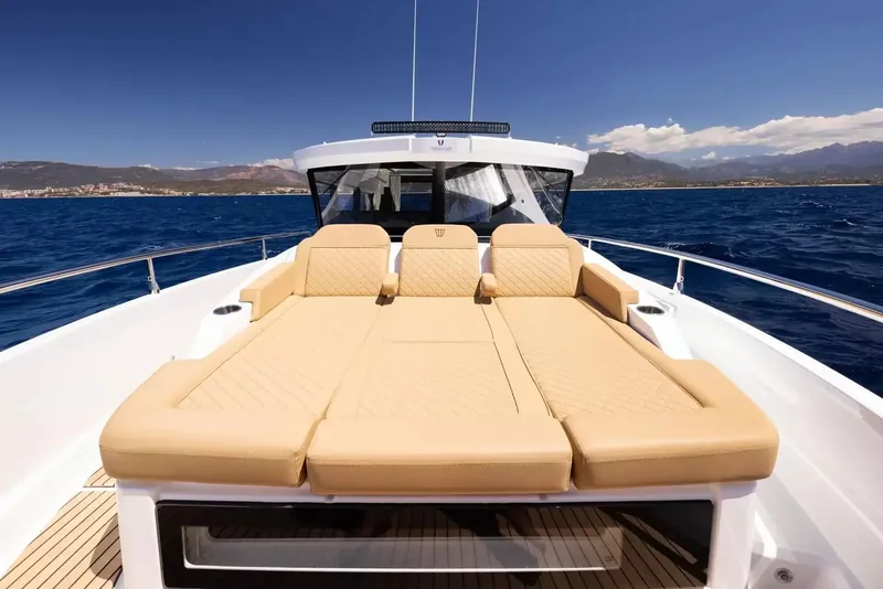 Slide: The Image of The image shows the foredeck of a Wellcraft 38 Explorer with beige cushions on the water. - 13
