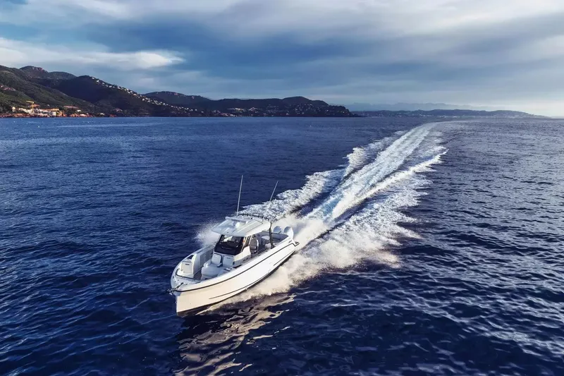 The Image of A Wellcraft 28 T-Top boat speeds across open sea, leaving a white wake behind. - 1