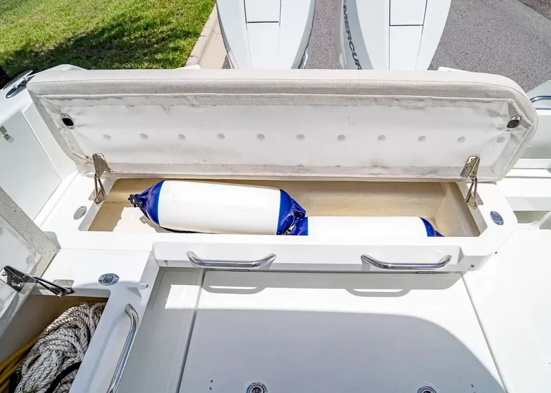 Slide: The Image of An open storage compartment on a Wellcraft 28 T-Top boat reveals fenders and ropes. - 10