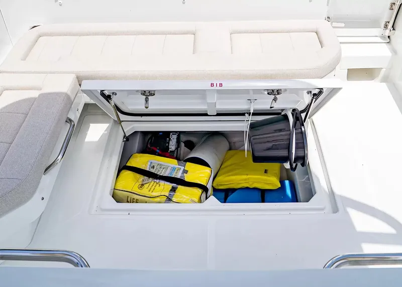Slide: The Image of An open storage compartment on a Wellcraft 28 T-Top boat reveals life jackets and equipment. - 9