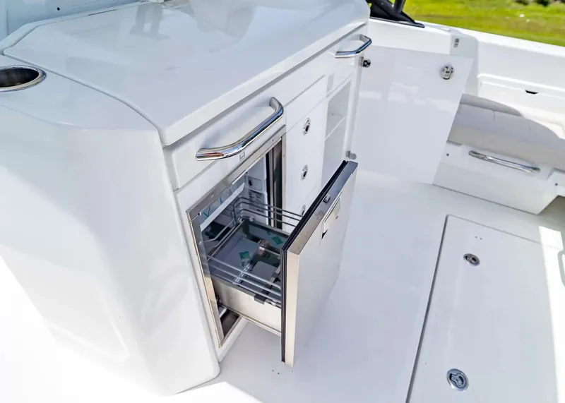 Slide: The Image of The 2027 Wellcraft 28 T-Top features a modern onboard kitchen with a stainless steel drawer refrigerator. - 15