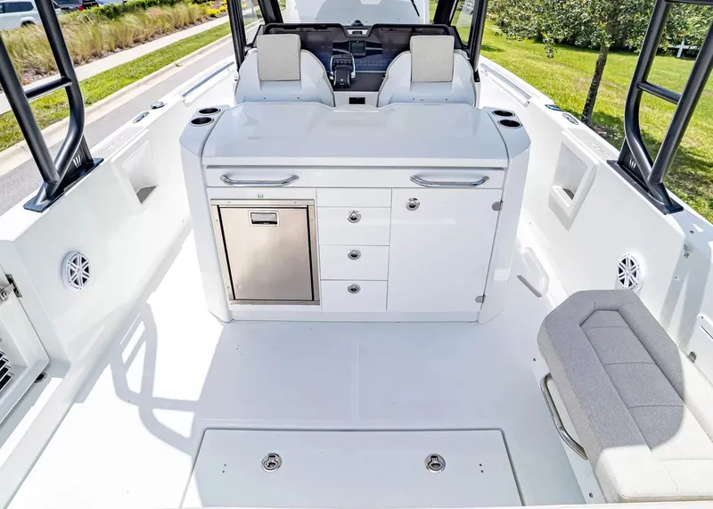 Slide: The Image of The image shows the cockpit of a 2027 Wellcraft 28 T-Top boat with white seating and a helm station. - 14