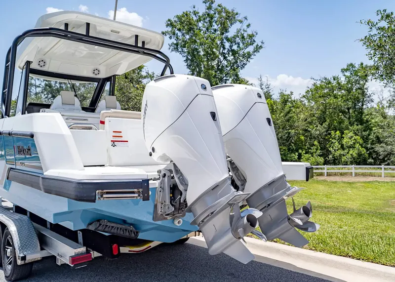 Slide: The Image of A 2027 Wellcraft 28 T-Top boat with twin outboard engines on a trailer. - 3