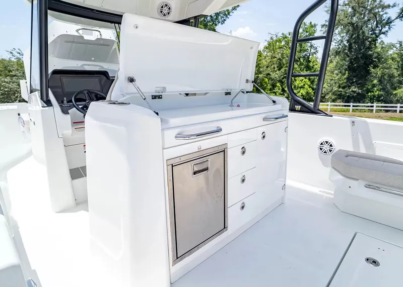 Slide: The Image of The image shows the cockpit of a 2027 Wellcraft 28 T-Top boat with a modern kitchenette. - 18