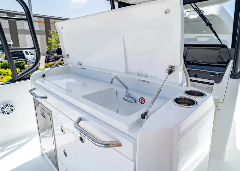 Slide: The Image of The 2027 Wellcraft 28 T-Top features a modern kitchenette with a sink and storage. - 17