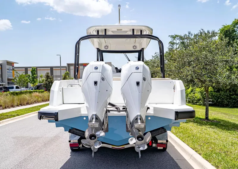 Slide: The Image of The image shows a 2027 Wellcraft 28 T-Top boat with twin outboard engines, parked on a trailer. - 4