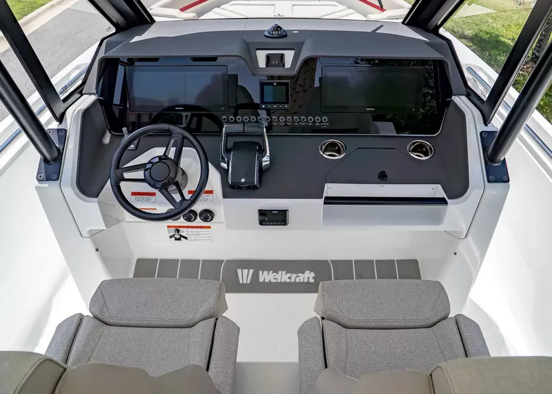 Slide: The Image of The image shows the cockpit of a 2027 Wellcraft 28 T-Top boat with modern instruments and gray seats. - 23
