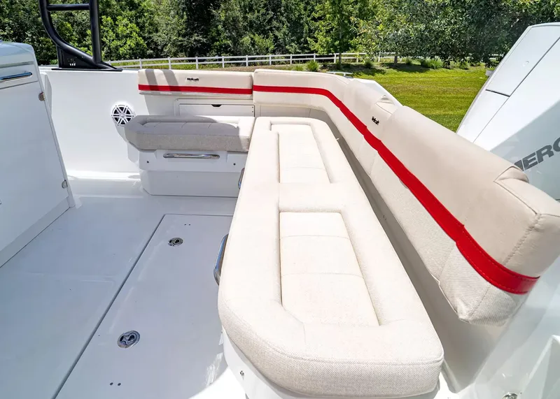 Slide: The Image of The 2027 Wellcraft 28 T-Top features a spacious, cushioned seating area with red accents. - 7
