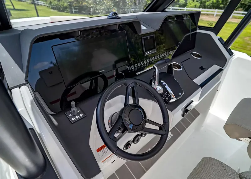 Slide: The Image of The image shows the cockpit of a 2027 Wellcraft 28 T-Top boat with modern instruments. - 25