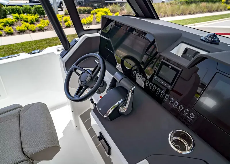 Slide: The Image of The image shows the cockpit of a 2027 Wellcraft 28 T-Top boat with modern steering and instruments. - 24