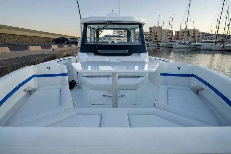 Slide: The Image of Wellcraft 28 Explorer 2027: Sleek design with spacious cockpit and comfortable seating in a harbor. - 18