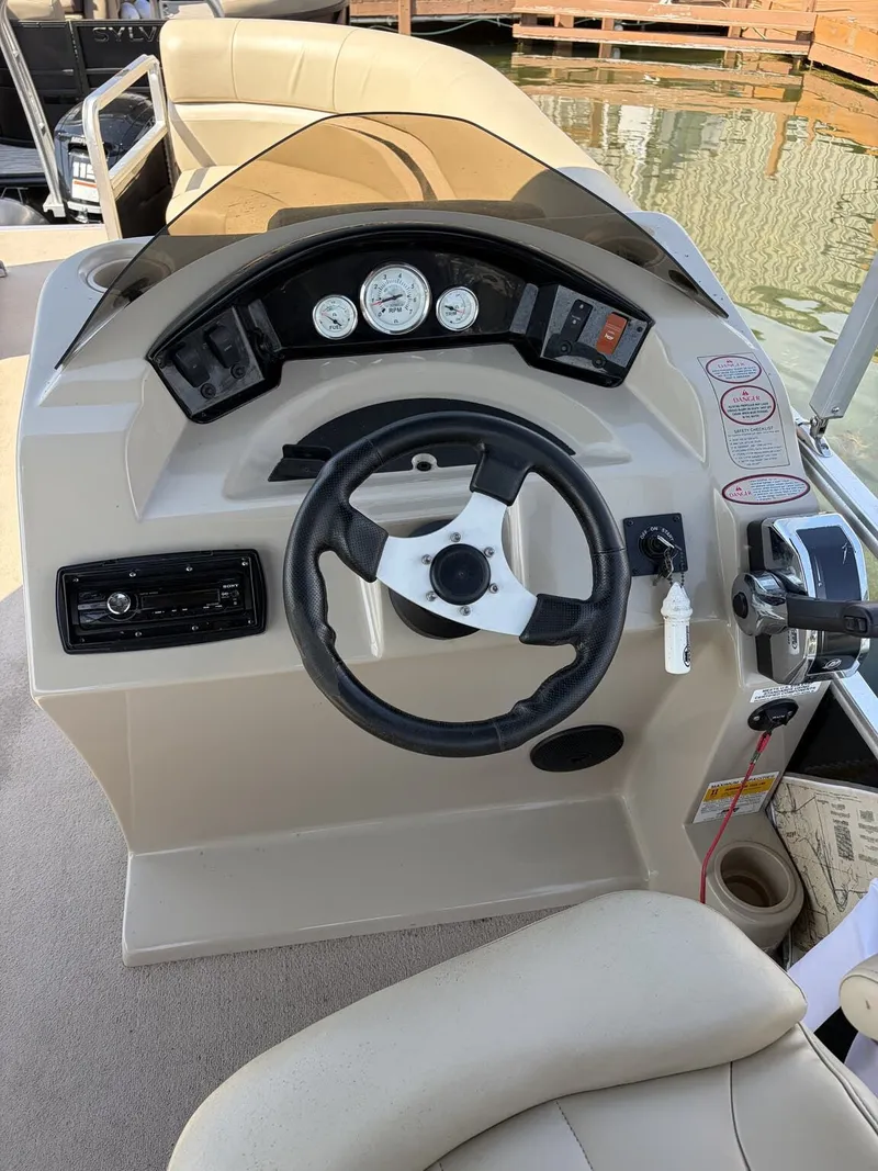 Slide: The Image of The image shows the helm of a 2012 Harris FloteBote Cruiser 200 CX200. - 7