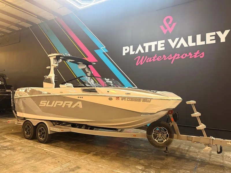 Slide: The Image of A 2022 Supra SA boat on a trailer inside a showroom. - 2