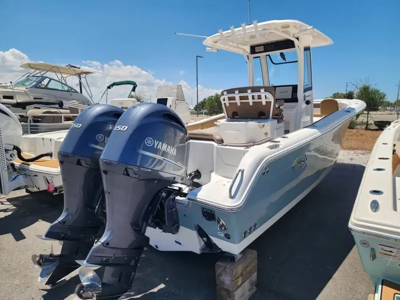 Slide: The Image of A 2021 Sea Hunt Ultra 265 SE boat with twin Yamaha engines is parked on a lot. - 2