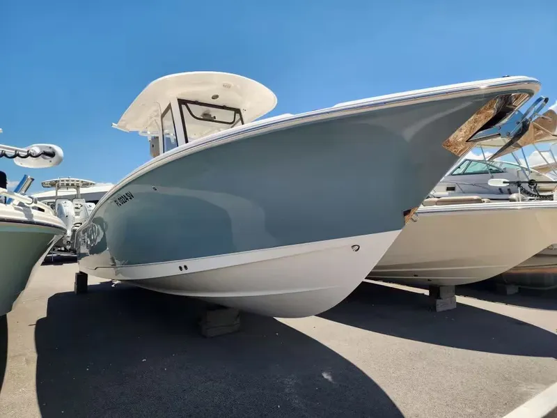 Slide: The Image of 2021 Sea Hunt Ultra 265 SE on a lot, featuring a blue hull and white deck. - 4