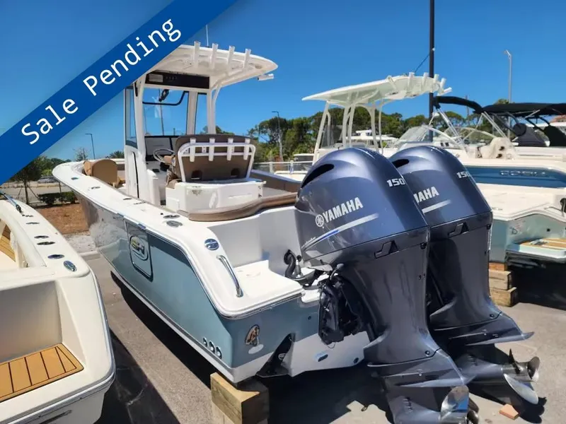 The Image of A 2021 Sea Hunt Ultra 265 SE boat with twin Yamaha engines, displayed in a parking area. - 1