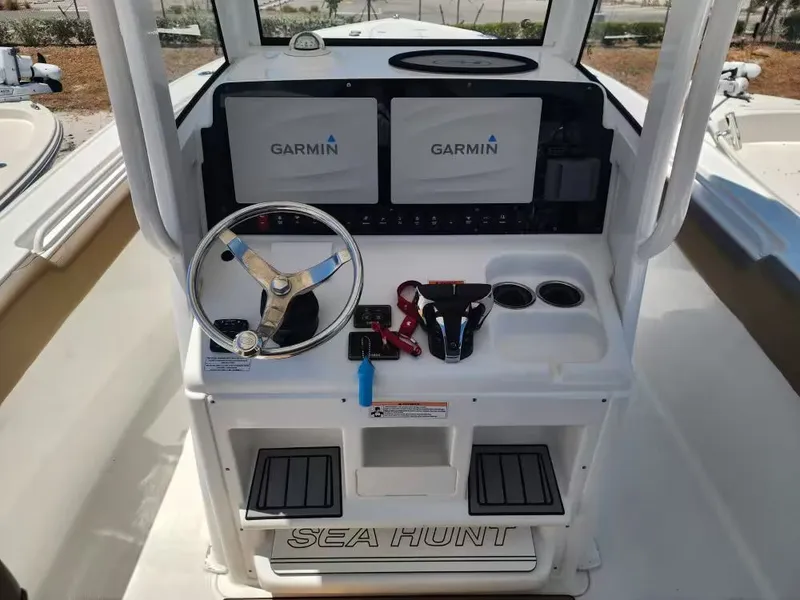 Slide: The Image of The image shows the helm of a Sea Hunt Ultra 265 SE boat with Garmin screens. - 10