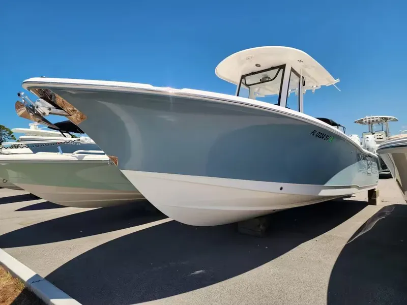 Slide: The Image of A 2021 Sea Hunt Ultra 265 SE boat is parked. It features a blue hull and white top. - 3