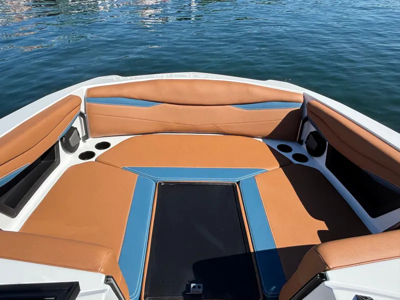 Slide: The Image of The image shows the bow of an Axis A225 boat with brown and blue upholstery. - 947