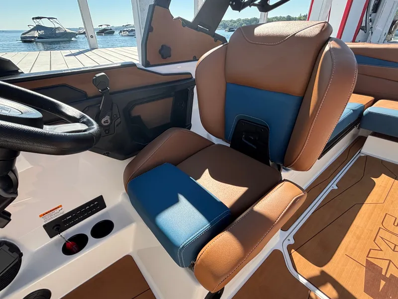 Slide: The Image of The image shows the interior of a 2026 Axis A225 boat with brown and blue seating. - 945