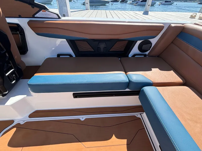 Slide: The Image of The image shows the interior of a 2026 Axis A225 boat with brown and blue upholstery. - 940