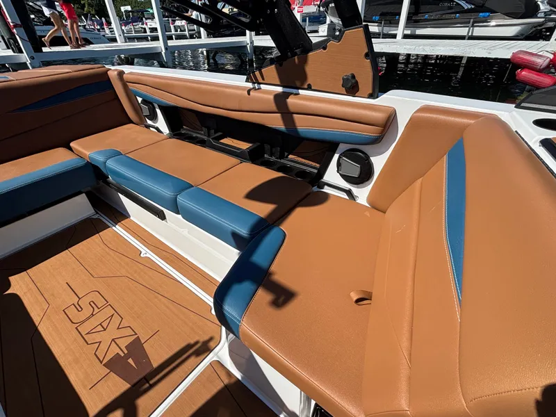 Slide: The Image of The image shows the interior of a 2026 Axis A225 boat with brown and blue seating. - 942
