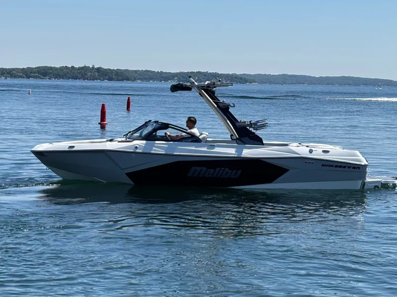 The Image of A white Malibu Wakesetter 23 LSV boat cruising on a calm lake. - 1