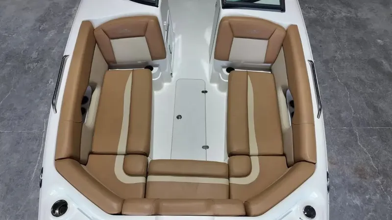 Slide: The Image of The 2023 NauticStar 243 DC features a spacious, cushioned seating arrangement in beige and brown. - 16