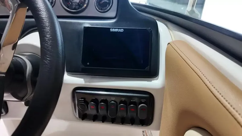 Slide: The Image of The image shows the dashboard of a NauticStar 243 DC boat with a Simrad display and switches. - 40