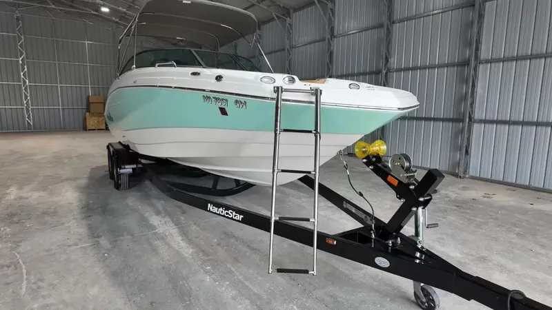 Slide: The Image of A 2023 NauticStar 243 DC boat on a trailer inside a warehouse. - 15