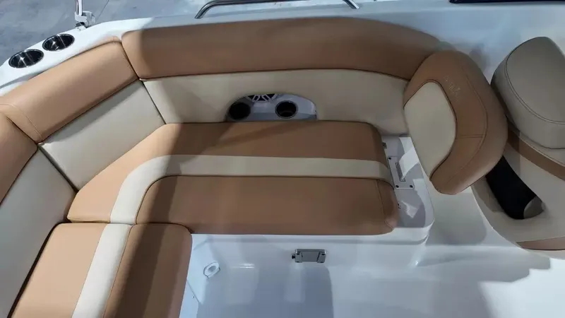 Slide: The Image of The 2023 NauticStar 243 DC features an elegant, cushioned seating area in beige and brown tones. - 50