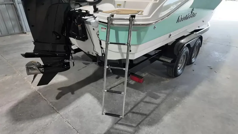 Slide: The Image of A 2023 NauticStar 243 DC boat with a retractable ladder at the stern, on a trailer. - 5