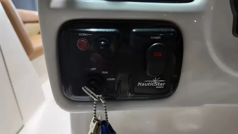 Slide: The Image of Close-up of the control panel on a NauticStar 243 DC boat with keys. - 35