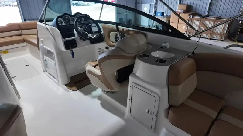 Slide: The Image of The image shows the cockpit of a 2023 NauticStar 243 DC boat with beige seating and a helm. - 33