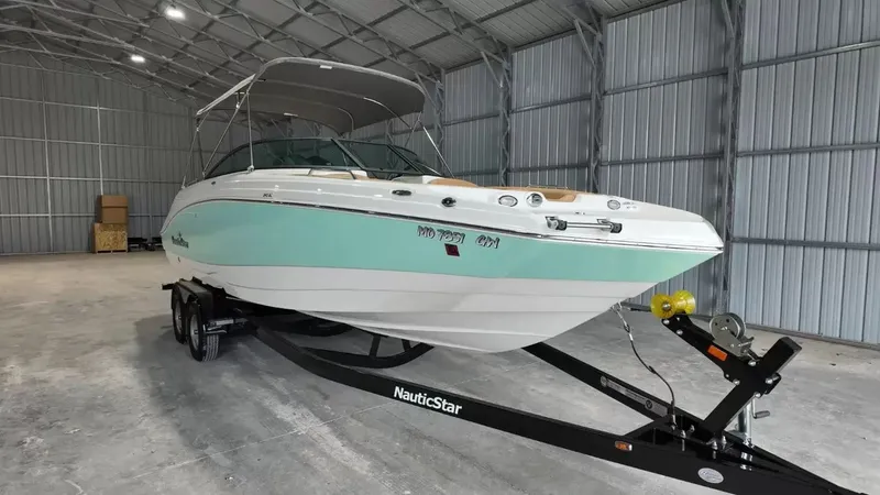 Slide: The Image of A 2023 NauticStar 243 DC boat on a trailer inside a warehouse. - 13