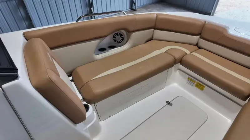 Slide: The Image of The image shows the seating area of a 2023 NauticStar 243 DC boat with beige upholstery. - 21