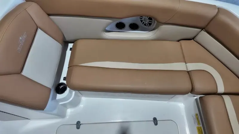 Slide: The Image of The image shows the seating area of a NauticStar 243 DC boat with brown upholstery and cup holders. - 19