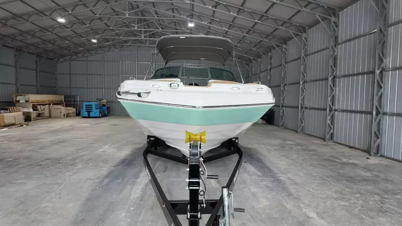 Slide: The Image of A 2023 NauticStar 243 DC boat is on a trailer inside a large warehouse. - 12