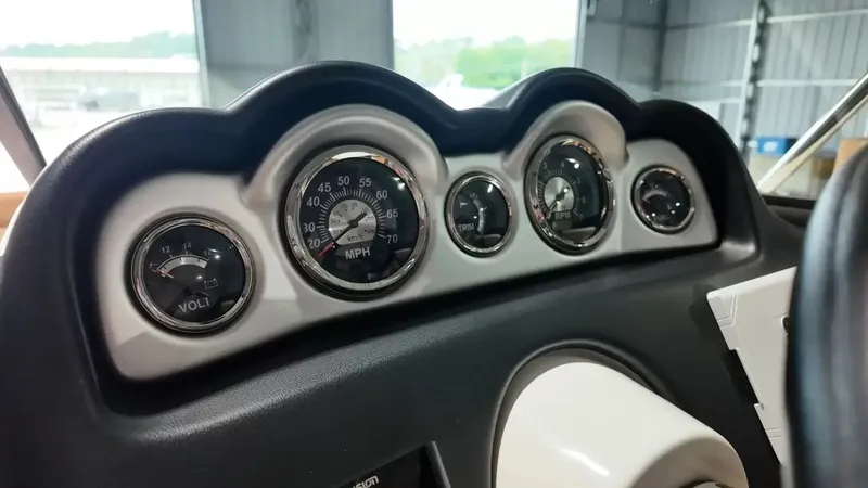 Slide: The Image of The dashboard of a 2023 NauticStar 243 DC features several analog gauges. - 37